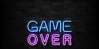 "Game Over" neon sign on brick wall.