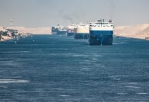 Multiple cargo ships in a narrow canal passage