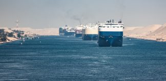Multiple cargo ships in a narrow canal passage