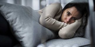 Person lying on couch looking sad and pensive
