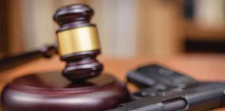 Gavel and handgun on a wooden surface