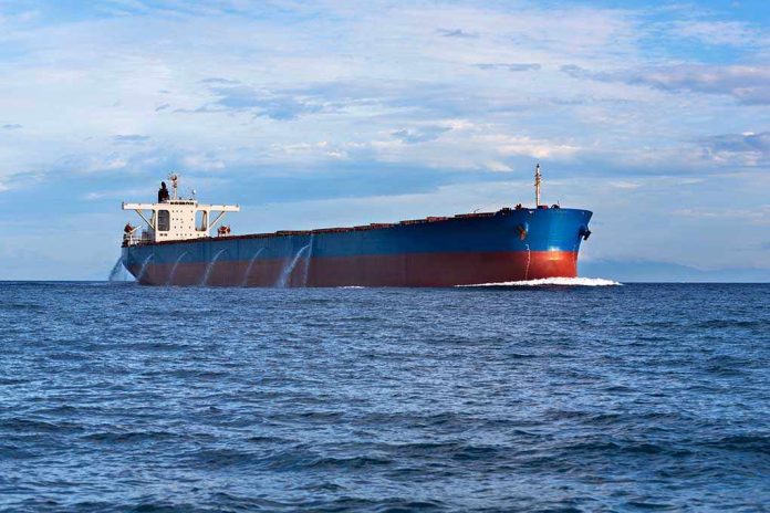 shutterstock_120534520.jpg A large cargo ship sailing on the ocean under a blue sky