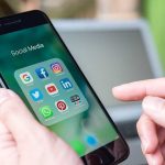 Federal Judge FREEZES State Social Crackdown — Why Now? Person holding phone with social media app icons