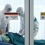 CDC Issues Dire Warnings Over New Outbreaks Healthcare workers in protective gear in quarantine room
