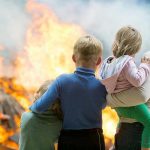 Utility Payouts STUN Eaton Fire Victims Three children and adult watching large fire outdoors