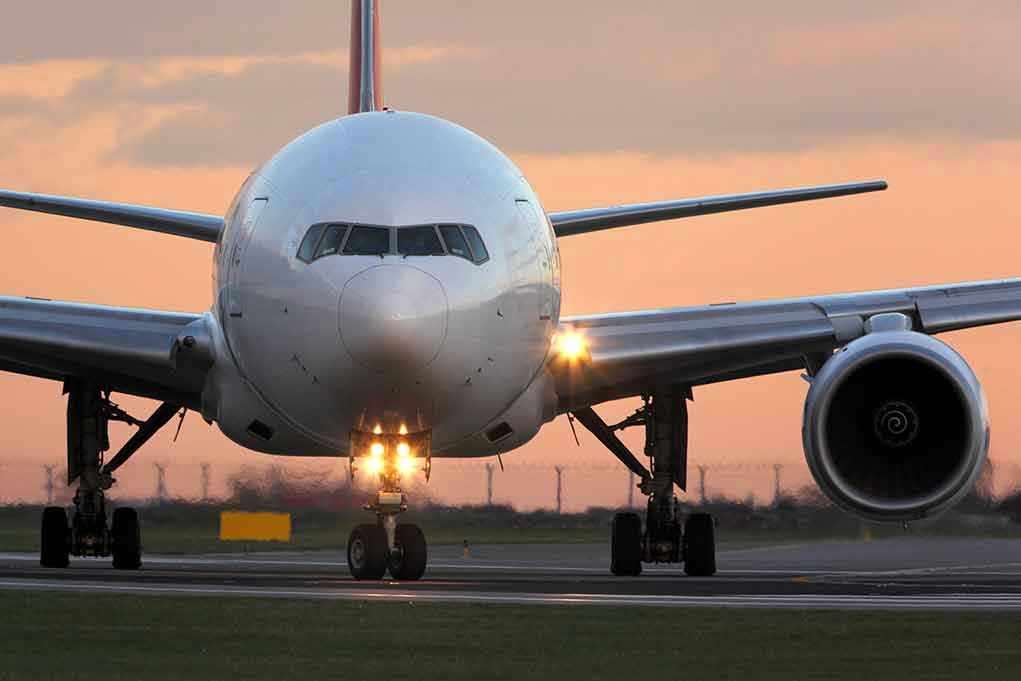 555148006 Airplane on runway during sunset