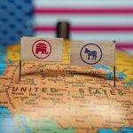 Trump Critic FLIPS SIDES—Stuns Party Loyalists Republican and Democratic flags on USA map background