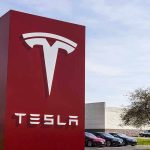 Tesla Slammed: $200 Million Autopilot Award Tesla sign in front of dealership