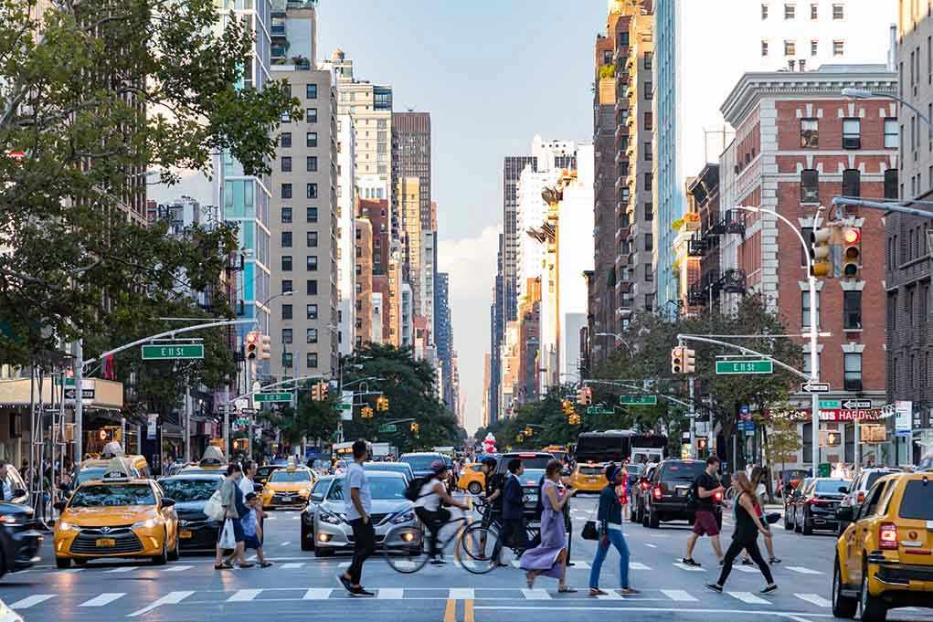 788608396 City street with pedestrian crossing and traffic.