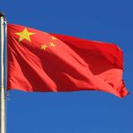 Leftist Critics Silenced as Tariffs Defy Predictions Chinese national flag waving against a clear blue sky