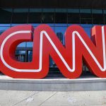 CNN WINS Major Court Battle — Conservatives Stunned Large red CNN sign outside building entrance.