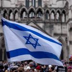 Hamas Leaders ELIMINATED – Great Day For Justice! Israeli flag at a crowded outdoor event.