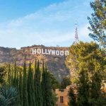 Celebs DENOUNCE DEMOCRATS—Hollywood Erupting! Hollywood sign on hill surrounded by trees and buildings.