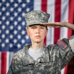 Hegseth’s BOLD STANCE: Higher Standards, Fewer Women! Soldier saluting in front of American flag backdrop.