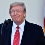 Trump CHARMS Leader – Secures Massive Deal! Man in suit and tie speaking at podium.