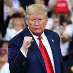 Trump STUNS With Impossible Deal – Best Yet? Man in suit making a fist gesture at rally.