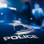 SHOCKING Police Oversight—5 Officers SUPSENDED! Police car with blurred figures in the background.