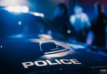 SHOCKING Police Oversight—5 Officers SUPSENDED! Police car with blurred figures in the background.