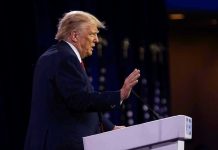 Trump Revives 50-Year Law – Billions SLASHED! Person speaking at a podium with hand raised