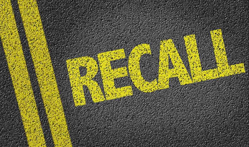 486784426 Yellow RECALL text on asphalt background.
