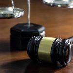 Shutdown Layoff Bombshell—Jobs REINSTATED! Gavel and scales of justice on wooden table.