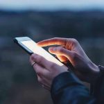 Leaked Kirk Texts Ignite Political FIRESTORM Person using a smartphone at dusk