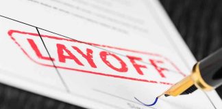 Close-up of a layoff notice with a signature line and a fountain pen