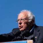 Sanders SLAMS Colleague— Dem Party Divided! A speaker passionately addressing a crowd at an outdoor rally