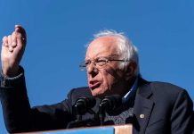Sanders SLAMS Colleague— Dem Party Divided! A speaker passionately addressing a crowd at an outdoor rally