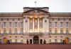 Royal Immunity OBLITERATED—Monarch in Chaos! Front view of Buckingham Palace with illuminated facade and British flag