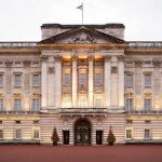 Royal Immunity OBLITERATED—Monarch in Chaos! Front view of Buckingham Palace with illuminated facade and British flag