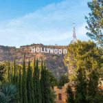 Oscar Winner HOMELESS – Hollywood Turns It’s Back Hollywood sign on hill surrounded by trees and buildings.