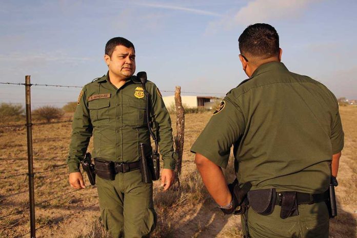 1641270949 Two uniformed officers standing outdoors near a fence.