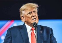 Trump Booed Off Stage—NFL Crowd Explodes Man in suit speaking at a microphone.