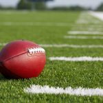 School Safety SHAKEN — Coach on the Run! A red American football resting on a green artificial turf field