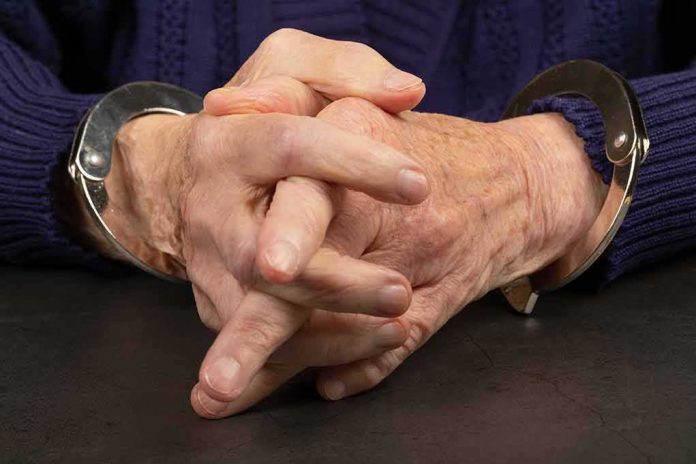shutterstock_1651479037.jpg Close-up of hands in handcuffs resting on a table