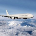 Massive Disruption: Airbus Recall Hits Peak Travel A white airplane flying above fluffy clouds in a blue sky