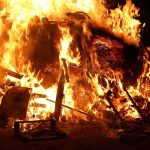 A large fire engulfing debris at night