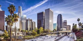 Downtown cityscape with skyscrapers and highway traffic.