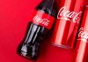San Francisco Declares War on Junk Food Giants Coca-Cola bottles and cans on red background.