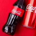 San Francisco Declares War on Junk Food Giants Coca-Cola bottles and cans on red background.