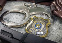 State Trooper PUNCHES Young Son’s Face Handcuffs, officer badge, and firearm on textured surface.