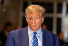 Man in blue suit and striped tie, serious expression.