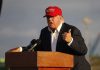 U.S. Peacebuilding in Jeopardy: Trump Takes Aim Person speaking at a podium wearing a red hat.
