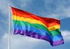 Church UPROAR: Pastor’s Gender Revelation A rainbow flag waving against a blue sky