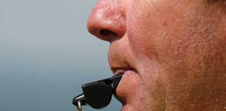 Close-up of a sports coach blowing a whistle