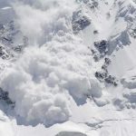 An avalanche occurring on a snowy mountain slope
