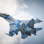 F-16 Thunderbird CRASH Shocks Military A blue camouflage fighter jet performing an aerial maneuver against a cloudy sky