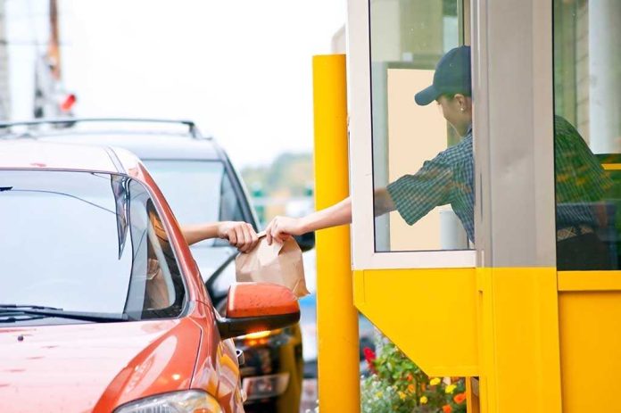 Customer receiving a food order at a drive-thru window