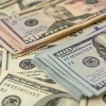 Stacks of various U.S. dollar bills.